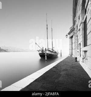 Schwarz-Weiß-Fotografie der Fondamenta Salute im Nebel mit einem historischen Segelschiff in Venedig, Italien Stockfoto