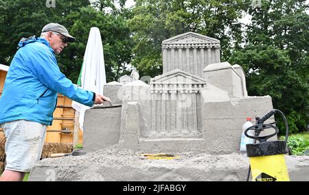 Ludwigsburg, Deutschland. 01.. Juli 2022. Der Künstler Kevin Crawford baut beim Sandskulptur Festival im Blossoming Baroque eine Sandskulptur nach dem Vorbild eines griechischen Tempels. In diesem Jahr werden Figuren aus Sand zum Thema „Reise durch Europa“ ausgestellt. Quelle: Bernd Weißbrod/dpa/Alamy Live News Stockfoto