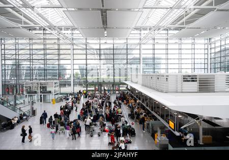 München, Deutschland. 01.. Juli 2022. Passagiere stehen an den Check-in-Schaltern am Flughafen München. Viele Passagiere warten noch eine Woche nach ihrem Zwischenstopp am Flughafen München auf ihr Gepäck. Quelle: Sven Hoppe/dpa/Alamy Live News Stockfoto