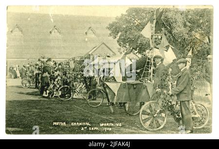 Original-Postkarte aus der Zeit Edwardians von einem Motorkarneval. Die Teilnehmer haben ihre Fahrräder mit Fahnen der patriotischen Union Jack dekoriert, ein Fahrrad wurde in ein Schiff verwandelt, Church of St. Francis, West Worthing, Sussex, England, UK vom 2. September 1908, Stockfoto