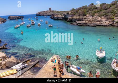 Menorca, Spanien - 30. Jun 2022: Baden in den transparenten Gewässern von Cala Alcaufar im Osten Menorcas Stockfoto