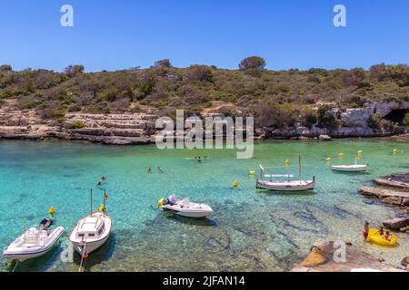 Menorca, Spanien - 30. Jun 2022: Baden in den transparenten Gewässern von Cala Alcaufar im Osten Menorcas Stockfoto