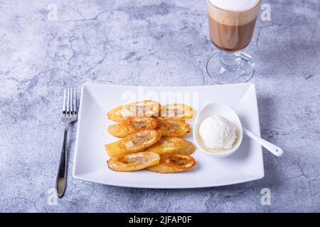 Gebratene Bananen mit Honig, Zimt, Kaffee und Eis. Nahaufnahme. Stockfoto