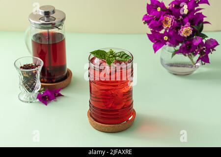 Frisch gebrühter roter Früchtetee auf dem grünen Tisch Stockfoto