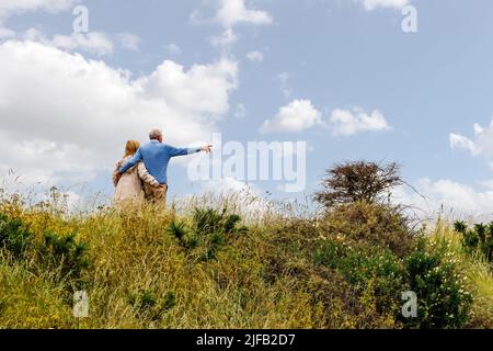 Liebende ältere Paare, die an einem Sommertag im Lymington und Keyhaven Marshes Nature Reserve spazieren gehen Stockfoto
