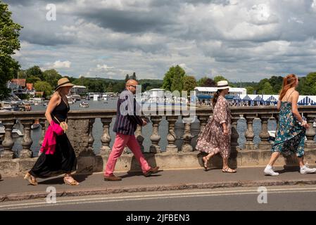 Henley-on-Thames, Oxfordshire, Großbritannien, Juli 1. 2022. Menschen überqueren die Henley Bridge auf dem Weg zur Henley Royal Regatta, mit den Regatta-Gebäuden und Booten im Hintergrund. Auf der Themse. Quelle: Martin Anderson/Alamy Live News Stockfoto