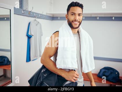 Porträt eines glücklichen Spielers in seinem Umkleideraum im Fitnessstudio. Gemischter Renner bereit für ein Squash-Match. Junger Mann, der sich nach einem Spiel in seinem Fitnessstudio entspannt. Junger Mann Stockfoto