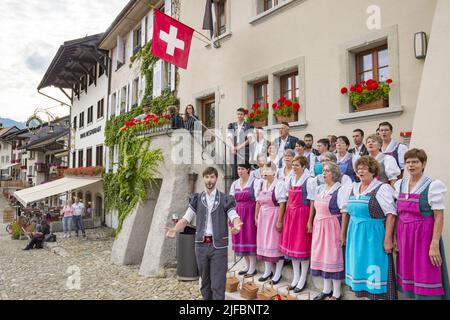 Schweiz, Kanton Friborg, Gruyères, mittelalterliche Stadt, ein traditioneller Chor spielt im Herzen des Dorfes Stockfoto