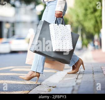 Unbekannte modische afroamerikanische Frau, die in der Stadt entlang der Straße spazierengeht und Einkaufstaschen nach dem Einkaufen trägt. High Fashion schwarze Frau Stockfoto