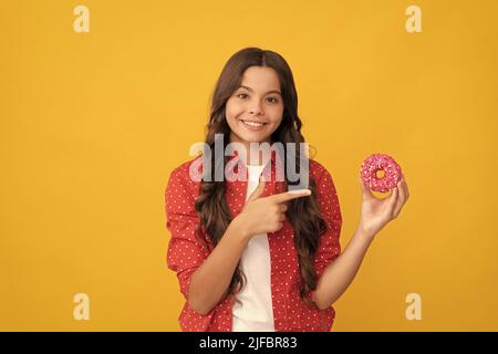 Happy Kid zeigen Finger auf süße glasierte Donut, Essen Stockfoto