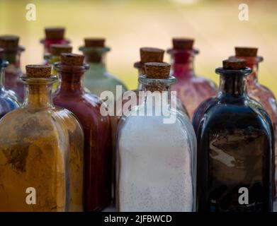 Mittelalterliche historische Nachstellung - Glasflaschen mit Korkstopfen mit Pulverfarben im Inneren, die zum Malen oder Färben von Kleidung und Leder verwendet werden Stockfoto