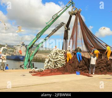 Männer, die im Hafen von Ceiro in Galicien, Spanien, mit Fischnetzen arbeiten Stockfoto