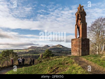 William Wallace Statue; Eildon Hills und ein weiter Blick auf die Landschaft der Grenzen im Hintergrund; Touring Bus Party von Touristen vor der Statue. Stockfoto