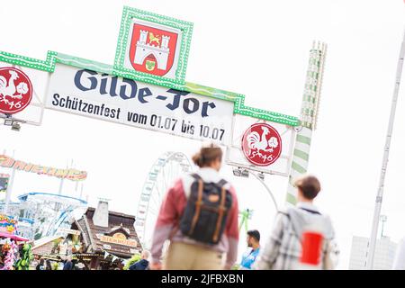 Hannover, Deutschland. 01.. Juli 2022. Besucher laufen auf das Gelände des Schützenfestes am Schützenplatz. Nach einer zweijährigen Pause aufgrund der Corona findet vom 01. Bis 10. Juli wieder das Schützenfest Hannover auf dem Schützenplatz statt. Kredit: Michael Matthey/dpa/Alamy Live Nachrichten Stockfoto