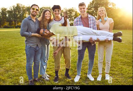 Portrait von lustigen jungen Freunden, die im Sommer im Park Spaß haben, lachen und herumtollten. Stockfoto