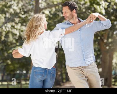 Liebevolles junges Paar, das einen romantischen Moment hat, während es einen Tanz teilt und zusammen im Hinterhof verbringt. Glückliche kaukasische Liebhaber sind verspielt und Stockfoto