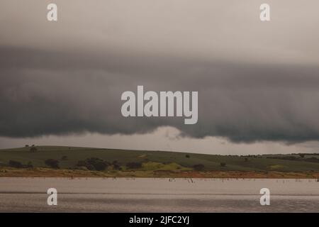 wolkiger Himmel unter dem Fluss Stockfoto