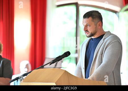 Baden Württemberg, Deutschland. 01.. Juli 2022. 01. Juli 2022, Baden-Württemberg, Brachenreuthe bei Überlingen: Taras Kostenko, Russe aus Charkow in der Ukraine, spricht beim Gedenkgottesdienst vor Dutzenden von Menschen, die an die Opfer des Flugzeugabsturzes in der Nähe von Überlingen am 1. Juli 2002 erinnern. Zu dieser Zeit wurden bei dem Zusammenstoß von zwei Flugzeugen 71 Menschen getötet. Foto: Felix Kästle/dpa Quelle: dpa picture Alliance/Alamy Live News Stockfoto