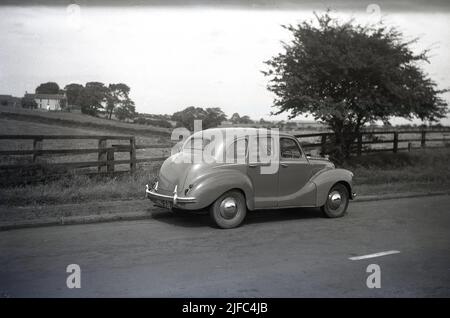 1950s, historische, hintere Seitenansicht eines Autos aus Austin der Ära, einer A40 auf einer Landstraße geparkten Limousine aus Devon, England. Der zwischen 1947 und 1952 produzierte Wagen war die erste Limousine der Austin Motor Company aus der Nachkriegszeit. Mit einer Mischung aus alten und neueren Technologien war der Wagen für seinen alten, konservativen Stil bekannt. Stockfoto