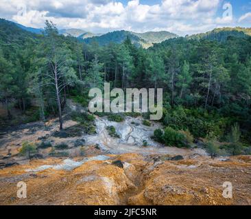 Wald verschmutzt mit Chemikalien aus verlassenen Pyritminen. Kiefern wachsen über Bergrückständen im Paphos-Wald, Zypern Stockfoto