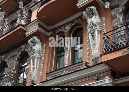 Kiew, Ukraine 28. November 2020: Künstlerische Dekoration der Fassade des Gebäudes mit Skulpturen und Büsten von Atlanten in der Stadt Kiew Stockfoto