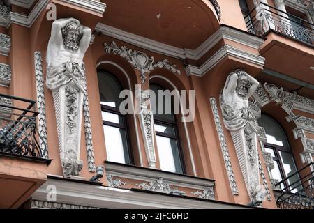 Kiew, Ukraine 28. November 2020: Künstlerische Dekoration der Fassade des Gebäudes mit Skulpturen und Büsten von Atlanten in der Stadt Kiew Stockfoto