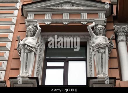 Kiew, Ukraine 28. November 2020: Künstlerische Dekoration der Fassade des Gebäudes mit Skulpturen und Büsten von Atlanten in der Stadt Kiew Stockfoto