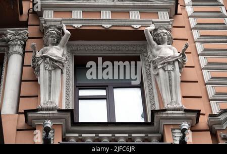 Kiew, Ukraine 28. November 2020: Künstlerische Dekoration der Fassade des Gebäudes mit Skulpturen und Büsten von Atlanten in der Stadt Kiew Stockfoto
