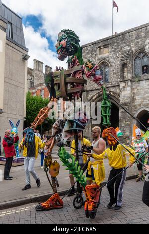 Winchester hat Fair, 1.. Juli 2022. Die jährliche Hutmesse begann heute mit lokalen Schulen, die an der Karnevalsprozession durch das Stadtzentrum mit den Kindern in bunten Kostümen teilnehmen. Die Winchester hat Fair ist ein 3-tägiges Outdoor Arts Festival mit Straßenunterhaltern und Aufführungen an verschiedenen Orten in der Stadt. EKO, eine 13 Meter hohe Seegigant-Marionette in der Karnevalsprozession. Stockfoto