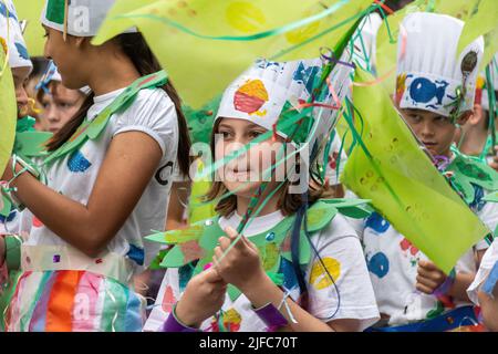 Winchester hat Fair, 1.. Juli 2022. Die jährliche Hutmesse begann heute mit lokalen Schulen, die an der Karnevalsprozession durch das Stadtzentrum mit den Kindern in bunten Kostümen teilnehmen. Die Winchester hat Fair ist ein 3-tägiges Outdoor Arts Festival mit Straßenunterhaltern und Aufführungen an verschiedenen Orten in der Stadt. Stockfoto