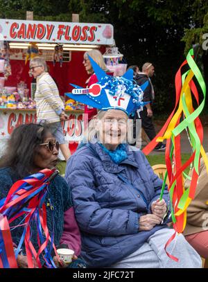 Winchester hat Fair, 1.. Juli 2022. Die jährliche Hutmesse begann heute mit lokalen Schulen, die an der Karnevalsprozession durch das Stadtzentrum mit den Kindern in bunten Kostümen teilnehmen. Die Winchester hat Fair ist ein 3-tägiges Outdoor Arts Festival mit Straßenunterhaltern und Aufführungen an verschiedenen Orten in der Stadt. Alte Menschen mit ausgefallenen Hüten genießen die Unterhaltung in Abbey Gardens. Stockfoto