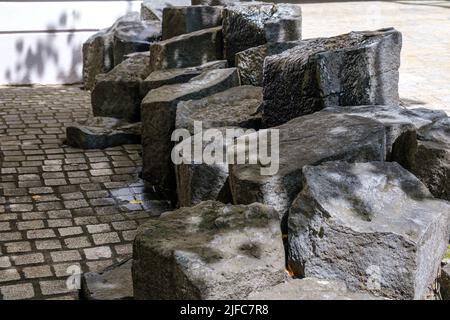 Hintergrund, Struktur, Struktur: Basaltformationen im Boden einer städtischen Umgebung; exemplarisch dargestellt durch einen Gang in Memmingen, Bayern, Deutschland. Stockfoto