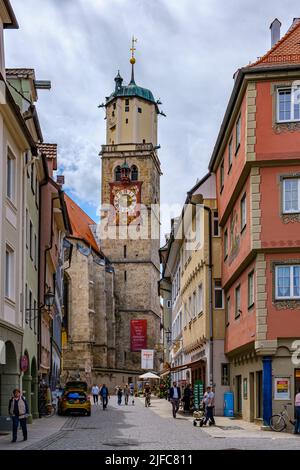 Memmingen im Unterallgäu, Schwaben, Bayern, Deutschland, Juni 8, 2022: Denkmalgeschützte Pfarrkirche St. Martin und belebte Zangmeisterstraße. Stockfoto