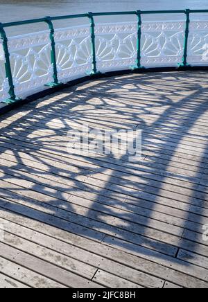 Schatten, die von der Iron Railings entlang des viktorianischen Pier Penarth, South Wales, Großbritannien, reflektiert werden Stockfoto