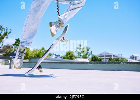 Nicht erkennbarer Mensch, der im Sommer gerne draußen in der Stadt ein Skateboard reitet. Nicht erkennbare Person Reiten ein Skateboard mit Energie in einem Stockfoto