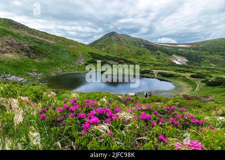 Lake Nesamovyte in den ukrainischen Karpaten. Der Hoverla-Gipfel der ukrainischen Karpaten hängt vor dem Hintergrund des Himmels und der Wolken Stockfoto