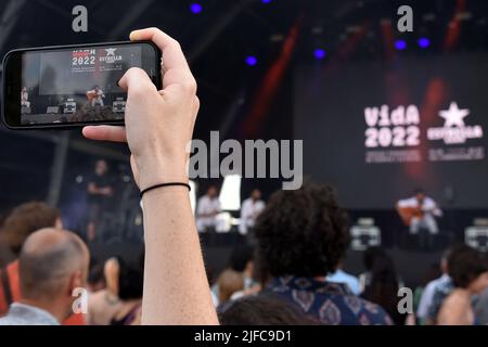 Ein Fan zeichnet mit seinem Smartphone die Darbietung des Flamenco-Sängers Israel Fernandez auf, seine Darbietung beim Vida 2022 Festival in Vilanova i la Geldru. Israel Fernández (geboren 1992 in Toledo) ist ein spanischer Flamenco-Sänger, Komponist und Musiker Zigeuner-Herkunft. Er wurde mit dem Odeon Award for Best Flamenco Album for Amor (2021) ausgezeichnet und für den Latin Grammy Award for Best Flamenco Music Album (2021) nominiert.Er begleitet ihn immer bei den Auftritten seines Gitarristen Diego el Morao. Stockfoto