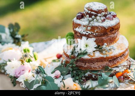 Schokoladenkuchen auf dem Tisch mit Blumen, freier Platz Stockfoto