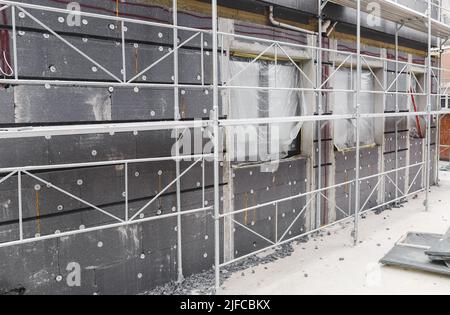 Gebäude und Bau. Bauarbeiten an einem Gebäude, Fassadenarbeiten, Fenster sind eingebaut Stockfoto