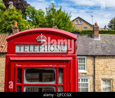 Pickering, Großbritannien - 9. 2022. Juni: Eine traditionelle rote Telefondose auf dem Bahnsteig am Pickering Bahnhof in der Stadt Pickering in North Yorkshir Stockfoto