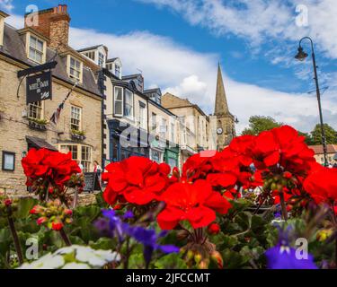 Pickering, Großbritannien - Juni 9. 2022: Blick auf den Market Place in der Stadt Pickering in North Yorkshire, Großbritannien. Der Turm der St. Peter und St. Pauls Kirche ist ich Stockfoto