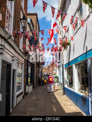 Whitby, Großbritannien - Juni 10. 2022: Blick auf Sandgate in der Küstenstadt Whitby in North Yorkshire, Großbritannien. Die Gewerkschaftsflagge hängt zum Gedenken an t Stockfoto