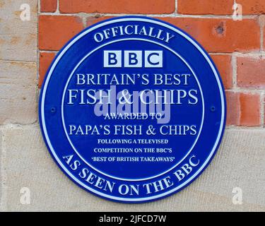Whitby, Großbritannien - 10. 2022. Juni: Eine Plakette auf der Außenseite eines Fisch- und Chipladens in Whitby, North Yorkshire - der Laden wurde zum besten Fisch gewählt Stockfoto