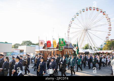 Hannover, Deutschland. 01.. Juli 2022. Teilnehmer eines Schützenzugs laufen nach dem Bruchmeister-Engagement über das Schützenfest auf dem Schützenplatz. Nach zwei Jahren koronabedingter Pause findet vom 01. Bis 10. Juli wieder das Schützenfest Hannover auf dem Schützenplatz statt. Kredit: Michael Matthey/dpa/Alamy Live Nachrichten Stockfoto