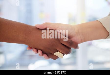Nahaufnahme von zwei unbekannten Geschäftsfrauen, die sich im Büro nach einem Treffen im Sitzungssaal die Hände schüttelten. Ambitionierte professionelle Kollegen mit Handschlag und Hand Stockfoto