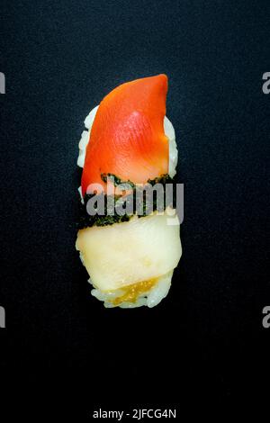 Jakobsmuschel-Nigiri-Sushi auf schwarzem Hintergrund Stockfoto