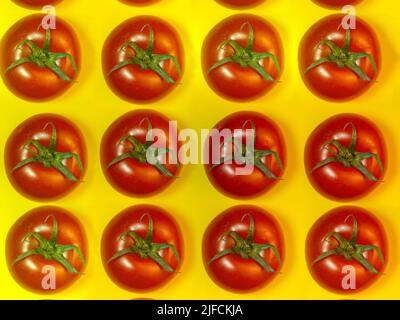 Tomate auf farbigem Papier. Gewächshaus Tomate auf einer Küche kleines Brett. Heller Gemüsehintergrund. Hintergrund von Tomaten. Stockfoto