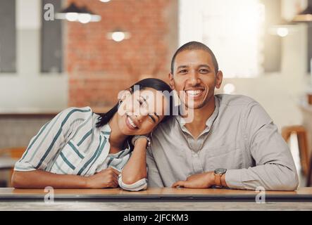 Portrait eines glücklichen, liebenden Mischrennpaares, das beim ersten Date Zeit zusammen genießt. Junge Frau und Mann auf einem Kaffee Datum in einem Café während des Tages Stockfoto