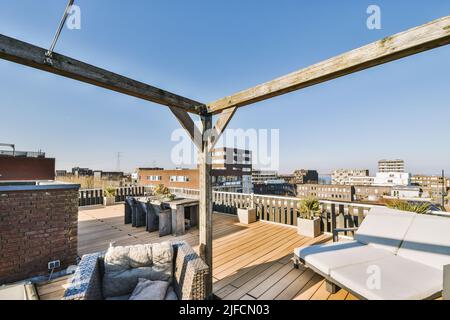 Blick auf die Stadt von der Terrasse mit Tisch und Stühlen auf dem Dach eines Mehrfamilienhauses Stockfoto
