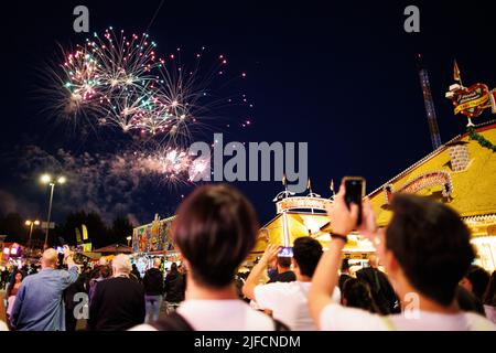 Hannover, Deutschland. 01.. Juli 2022. Besucher des Schützenfestes beobachten das Feuerwerk auf dem Schützenplatz zur Eröffnung des Festivals. Nach einer zweijährigen Pause aufgrund der Corona findet vom 01. Bis 10. Juli wieder das Schützenfest Hannover auf dem Schützenplatz statt. Kredit: Michael Matthey/dpa/Alamy Live Nachrichten Stockfoto